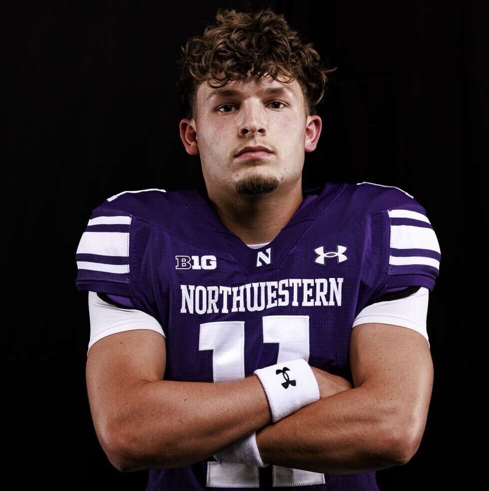 Football player in purple Northwestern jersey with arms crossed, showcasing athleticism and team spirit, relevant to the Blinds by Valeri's emphasis on precision and teamwork in home design projects.